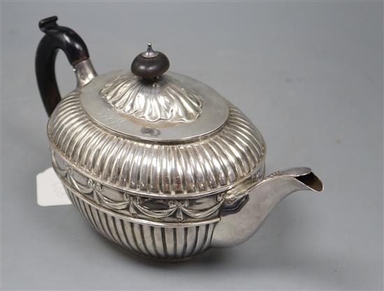 A Victorian fluted silver oval teapot by William Hunter, London, 1886, gross 20.5oz, with engraved initials.